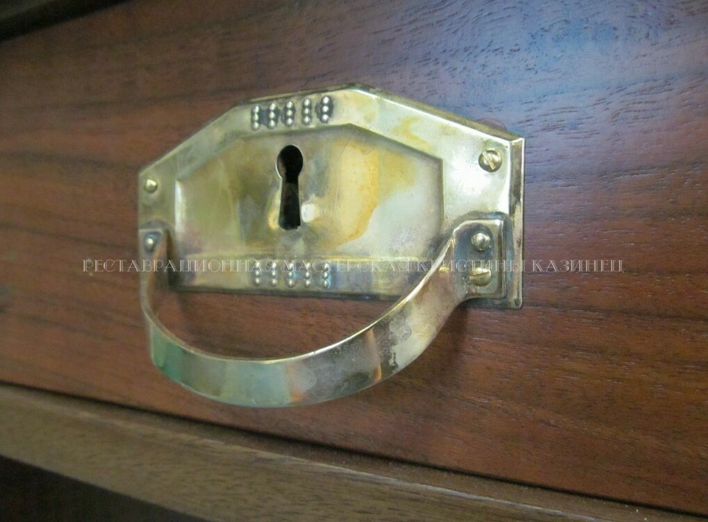 Латунная ручка на ящике старинного стола